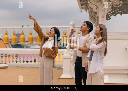 Gruppo di turisti asiatici che si godono un viaggio spirituale, sperimentando i punti di riferimento e la cultura thailandese Foto Stock