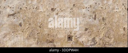 Pareti in stucco ruvido con fori proiettili che rivelano l'invecchiamento e l'usura storici Foto Stock