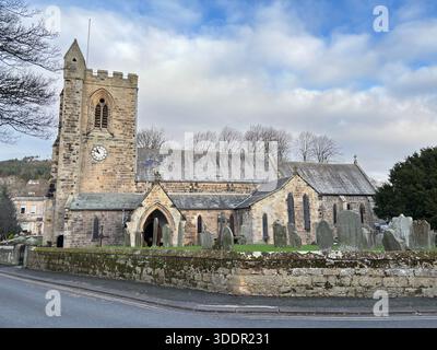 Edificio storico in pietra della chiesa All Saints nel villaggio di Rothbury in Inghilterra con navata, torre e dettagli architettonici. Foto Stock