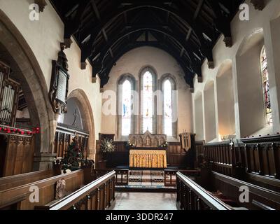 Edificio storico in pietra della chiesa All Saints nel villaggio di Rothbury in Inghilterra con navata, torre e dettagli architettonici. Foto Stock
