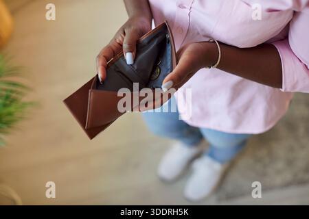 Donna afroamericana irriconoscibile con portafoglio vuoto, primo piano Foto Stock