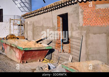 Campo de Criptana, Spagna - 8 dicembre 2025: Un cantiere in campo de Criptana, Spagna, con un mulino a vento visibile sullo sfondo, la scena presenta Bu Foto Stock