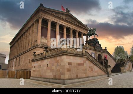 BERLINO-Germania-19 aprile 2025, l'alte Nationalgalerie, un museo neoclassico sull'Isola dei Musei di Berlino, si erge contro un cielo drammatico e colorato al sole Foto Stock