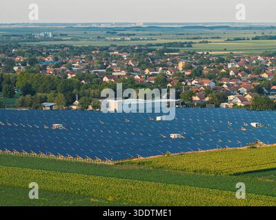 Il volo con drone sorvola il campo di pannelli solari il concetto di energia alternativa verde rinnovabile vicino alla città Foto Stock