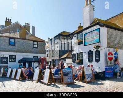 Sloop Inn sul posto sin dal 1312 circa la casa pubblica e la terrazza ristorante Sloop Shack piena di turisti St Ives Cornovaglia Inghilterra Regno Unito Europa Foto Stock