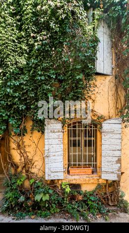 Arles, Francia, 9 settembre 2023, veduta di una vecchia casa gialla con un impianto di arrampicata e alcune persiane di legno su Grand Couvent Street Foto Stock