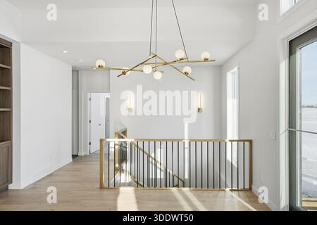 Grande lampadario appeso al soffitto in una stanza bianca. Il lampadario è realizzato in oro e ha molte luci. La camera era molto luminosa e pulita Foto Stock