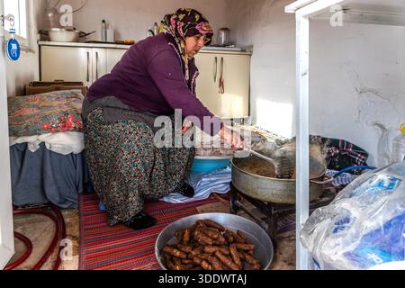Un cuoco frigge polpette di carne tritate conosciute come Ürgüp köftesi nella piccola cucina del ristorante Tık Tık Kadın Emeği a Ürgüp, in Turchia. Fondata nel 2018, la cooperativa femminile finanzia borse di studio per circa 50 studentesse con i suoi proventi ed è stata nominata "Ristorante consigliato" della Guida Michelin nel 2026. Foto Stock