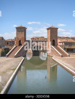 Vista dello storico ponte Trepponti e della sua riflessione nel canale. Iconica architettura in mattoni e punto di riferimento di Comacchio nel Parco del Delta del po, Ferra Foto Stock