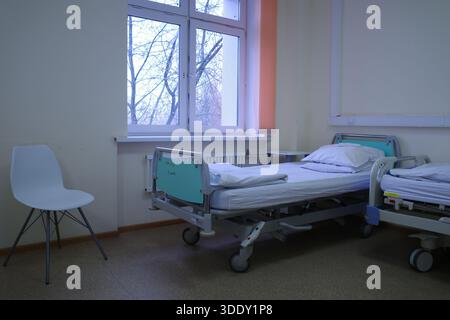 Camera d'ospedale vuota con letto e sedia Foto Stock