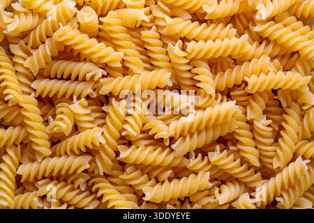 Primo piano di pasta fusilli cruda. Pasta italiana, consistenza dei coni di pasta, vista dall'alto Foto Stock