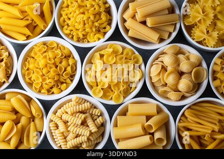 Composizione con diverse gustose paste crude - carta da parati per pasta italiana, diversi tipi e forme di layout per pasta Foto Stock