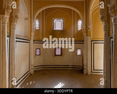 Piccole finestre dell'Hawa Mahal a Jaipur, viste dall'interno, con raggi di sole e nessuna gente. Foto Stock
