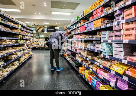 Londra Regno Unito, 3 gennaio 2026, One Man Alone Food Shopping Sfoglia i dessert al forno sugli scaffali del supermercato Foto Stock