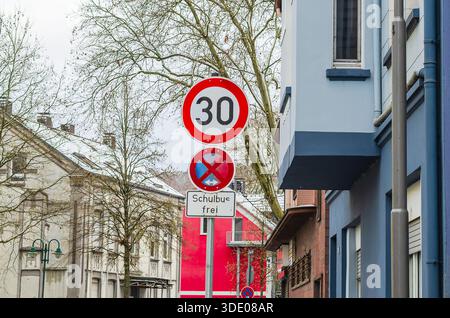 Segnali stradali tedeschi che indicano un limite di velocità di 30 km/h e la zona dello scuolabus Foto Stock