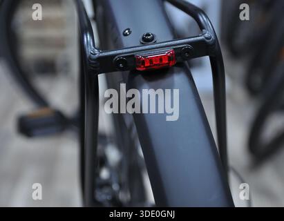 Primo piano di una luce posteriore per bicicletta montata su un portabagagli, sicurezza per il ciclismo e concetto di trasporto urbano. Foto Stock