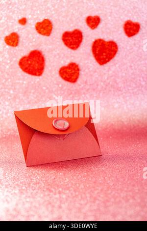 Sfondo romantico. Busta rossa con una confessione d'amore, il cuore di Valentine. Una dichiarazione d'amore alla persona più vicina. Festa della mamma, matrimonio annientato Foto Stock