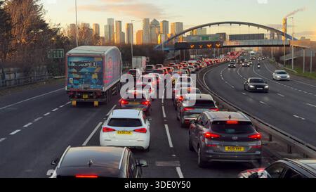 Londra Greenwich, Regno Unito, 4 gennaio 2025. Il trasporto per l'autobus di Londra, coinvolto nel traffico pesante sulla A102, si avvicina al Blackwall Tunnel temporaneamente chiuso in direzione nord, interessando sia i trasporti pubblici che i veicoli privati durante l'ora di punta serale. L'ampia vista mostra la portata della congestione con le torri di Canary Wharf visibili, dimostrando l'impatto sull'accesso al quartiere degli affari. La chiusura del tunnel interrompe il percorso di attraversamento del Tamigi, con veicoli commerciali, autobus e automobili in coda sulla strada di avvicinamento da allora il tunnel è stato riaperto e il flusso del traffico è tornato normale. Credito: Glosszoom/Alamy Live News Foto Stock