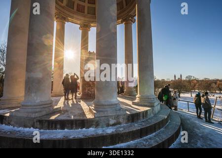 Die tiefstehende Wintersonne strahlt durch die Säulen des monopteros, ein klirrend kalter Wintertag im Englischen Garten, Sonntag, München, Januar 2026 Deutschland, München, Januar 2026, monopteros im Englischen Garten, viele Menschen genießen den strahlend schönen Wintertag im Park, Die tiefstehende Wintersonne strahlt zwischen den Säulen des monopteros, Blick vom monopteros auf den malerisch verschneiten Park, am Horizont die Stadtsilhouette, Sonntagnachmittag, frostige che Temperland, Winterluft, Winterluft, Winterluft, Winterluft 4 Graftsilhouette, Winterluft, Winterluft, Winterluft, Winterluft, Winterlend, Kälte Winterhimmel, Architektur, Bayern, *** il basso Foto Stock
