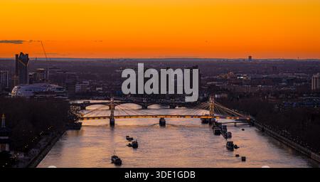 Vista panoramica dell'Albert Bridge sul fiume Tamigi all'ora d'oro, che collega Chelsea e Battersea mentre lo skyline di Londra si illumina; per i viaggi, i trasporti, Re Foto Stock