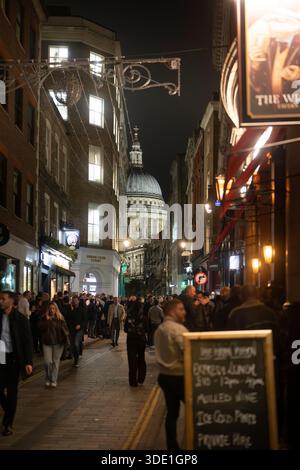 La gente passeggia davanti alla Cattedrale di St. Paul a Londra di notte, godendosi l'atmosfera vibrante della città. Foto Stock