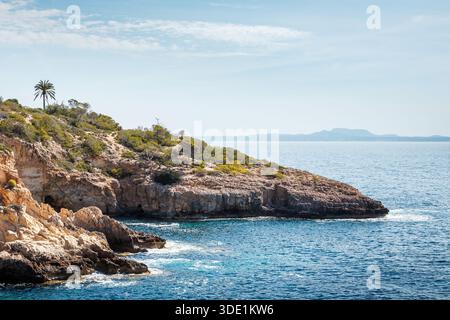 Mare blu e scogliere vicino alla spiaggia di Cala Cap Falco a Maiorca, Spagna. Splendido paesaggio naturale sulle Isole Baleari Foto Stock