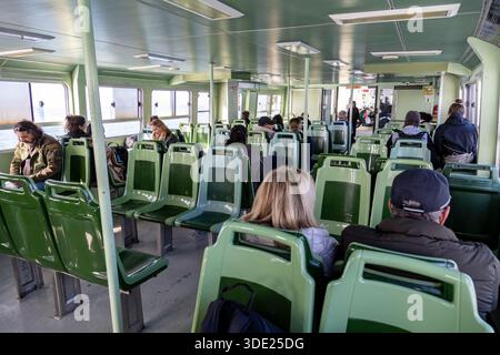 Chioggia, Italia - 25 ottobre 2025: Passeggeri seduti all'interno di un vaporetto ACTV che effettua la rotta Chioggia-Pellestrina attraverso la laguna di Venezia Foto Stock