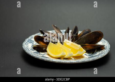 Cozze al vapore con piatto vintage al limone - antipasto di pesce, cucina mediterranea e ristorante Foto Stock