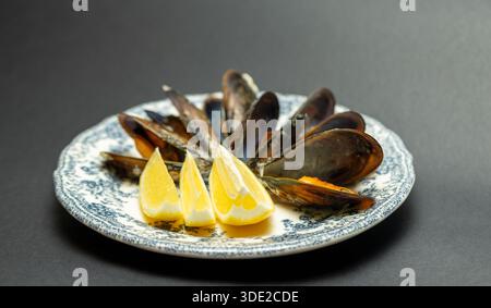 Cozze al vapore con piatto vintage al limone - antipasto di pesce, cucina mediterranea e ristorante Foto Stock
