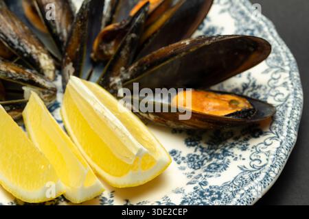 Cozze al vapore con piatto vintage al limone - antipasto di pesce, cucina mediterranea e ristorante Foto Stock