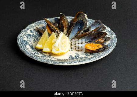 Cozze al vapore con piatto vintage al limone - antipasto di pesce, cucina mediterranea e ristorante Foto Stock