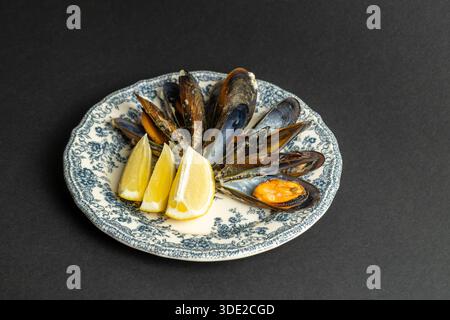 Cozze al vapore con piatto vintage al limone - antipasto di pesce, cucina mediterranea e ristorante Foto Stock