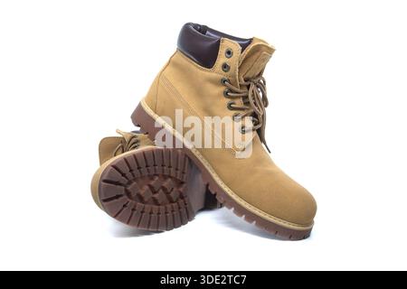 Un paio di stivali da lavoro scamosciati color marrone con colletti in pelle, occhielli in metallo e spesse suole con alette in gomma per una trazione e un sostegno eccellenti Foto Stock