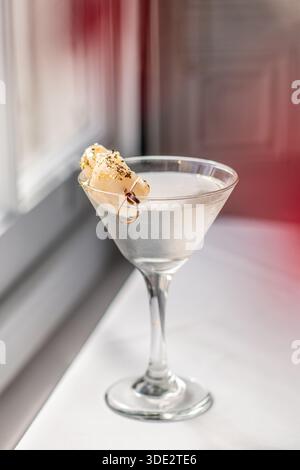 Elegante cocktail martini al litchi servito in un classico bicchiere di martini, con vodka, liquore al litchi e succo di litchi. Foto Stock