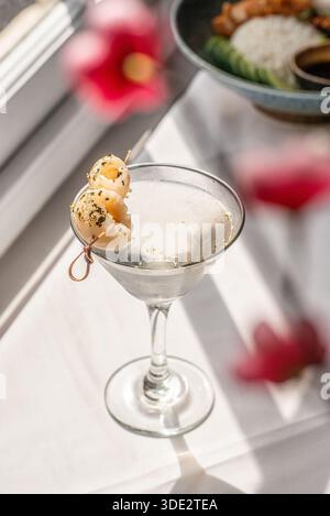 Elegante cocktail martini al litchi servito in un classico bicchiere di martini, con vodka, liquore al litchi e succo di litchi. Foto Stock