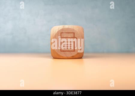 Cubo in legno con un'icona stampata, che rappresenta la creatività, il design e l'artigianato minimalista, ideale per l'ufficio, scopi educativi o decorativi Foto Stock