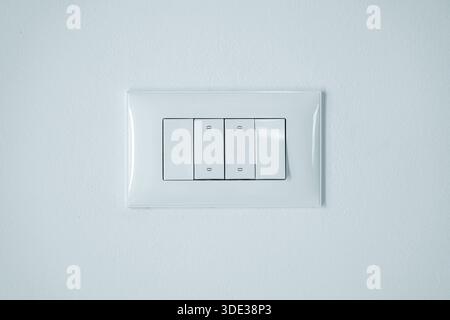 Interruttori moderni di luce bianca sul pannello lucido, primo piano Foto Stock