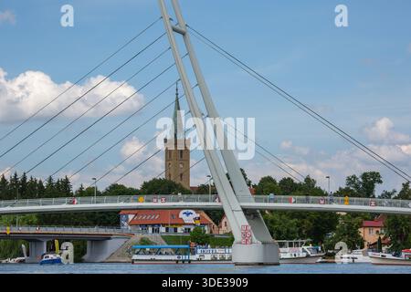 Mikolajki, Masurian Lake Land, Masuria, Polonia - 24 giugno 2020: Vista dal lago Mikolajskie del ponte sospeso, porticciolo per yacht e barche Foto Stock