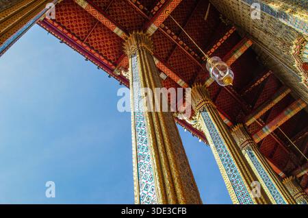Foto dettagliata del colorato tetto piastrellato e delle intricate decorazioni dorate di un tradizionale tempio buddista. L'immagine mostra il motivo artistico A. Foto Stock