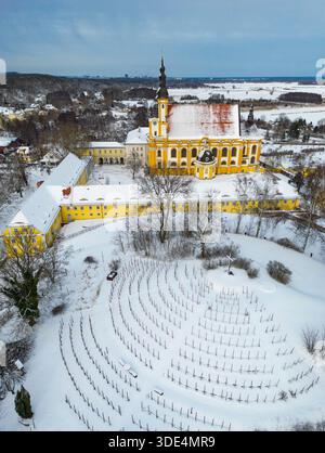 Neuzelle, Germania. 3 gennaio 2026. La chiesa cattolica e il vigneto del monastero di Neuzelle sono ricoperti di neve (vista aerea con un drone). Il monastero di Neuzelle, a circa dieci chilometri a sud di Eisenhüttenstadt, è l'unico monastero cistercense completamente conservato nel Brandeburgo, compresi i terreni, e uno dei pochi complessi monastici non distrutti in Germania e in Europa. Crediti: Patrick Pleul/dpa/Alamy Live News Foto Stock