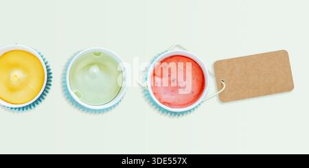 Assortimento minimalista di gelati senza latticini in tazze pastello con etichetta Kraft vuota per il marchio. Moderno concetto estetico di dessert vegani, senza lattosio Foto Stock