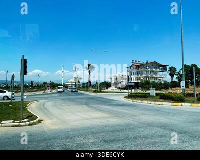 Antalya, Turchia - 12 luglio 2021: Rotonda trafficata in una città costiera con veicoli, palme e un hotel moderno in Turchia. Foto Stock