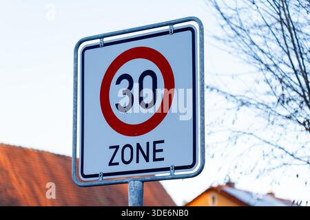 Rotondi i segnali stradali a 30 zone che limitano la velocità del veicolo in un'area urbana Foto Stock