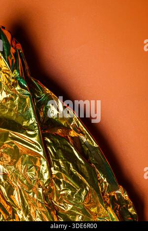 Primo piano della trama dorata incrociata su uno sfondo arancione pieno. Spazio copia o copia. Ideale per l'uso come sfondi, sovrapposizioni o elementi di design Foto Stock