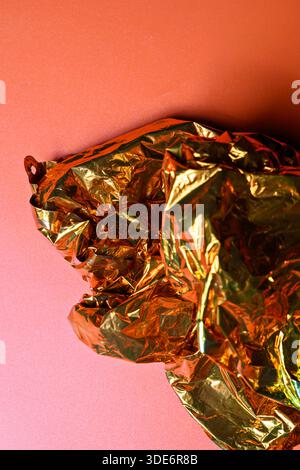 Primo piano della trama dorata incrociata su uno sfondo arancione pieno. Spazio copia o copia. Ideale per l'uso come sfondi, sovrapposizioni o elementi di design Foto Stock