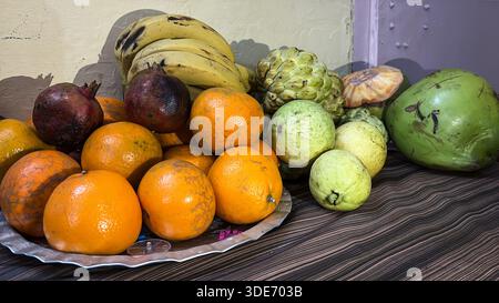 frutta fresca mista con banane, arance, mele con crema pasticcera e melograno al banco della frutta Foto Stock