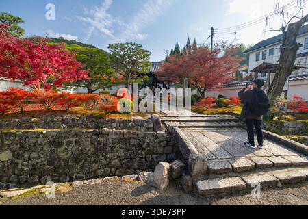 Il tempio di Enkōji a Kyoto presenta una vivace vegetazione autunnale e un paesaggio tradizionale giapponese. Viene catturato un visitatore che documenta il paesaggio Foto Stock