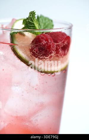 Primo piano del succo di lampone rosa frizzante con lime e menta Foto Stock