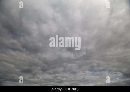 Una splendida vista di un vasto cielo nuvoloso con una splendida miscela di sfumature grigie e formazioni di morbide nuvole Foto Stock