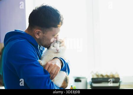 Uomo con gatto carino. Animali domestici e umani amicizia, amore e fiducia Foto Stock